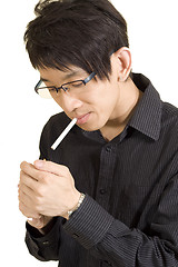 Image showing Young Asian man smoking