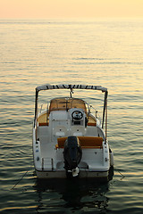 Image showing backside of motorized boat with sunset