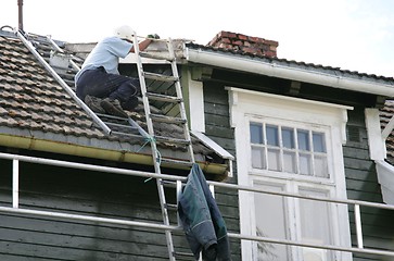 Image showing Painter on a roof
