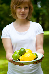 Image showing Girl holding a bowl of lemon and lime