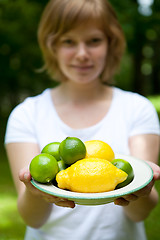 Image showing Girl holding a bowl of lemon and lime