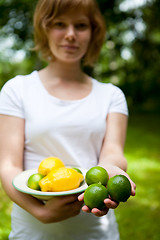 Image showing Girl holding a bowl of lemon and lime