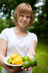 Image showing Girl holding a bowl of lemon and lime