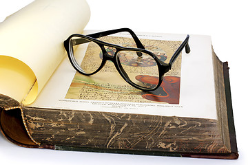 Image showing An open old book and spectacles