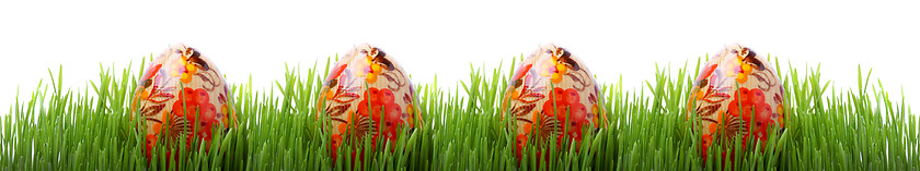 Image showing Easter eggs in the grass isolated on white 