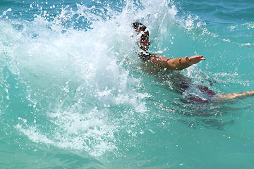 Image showing 10 years old child is swimming in waves