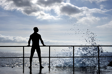 Image showing Silhouette of young man standing at the seaside