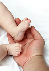 Image showing baby foots on father palm