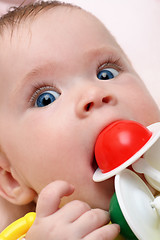 Image showing baby girl biting rattle