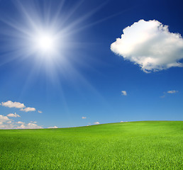 Image showing green hill under sky with sun