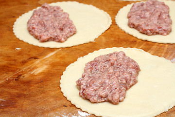 Image showing half-finished patty on wooden board