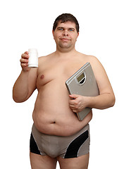 Image showing overweight man with medicaments and scales