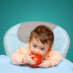 Image showing small baby biting tomato