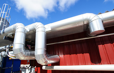 Image showing industrial pipelines on pipe-bridge against blue sky 