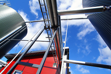 Image showing industrial pipelines on pipe-bridge against blue sky 