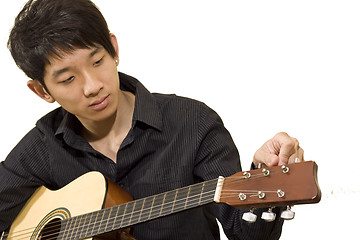 Image showing asia boy plays his guitar 