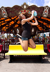 Image showing Fun girl jumping at Carousel