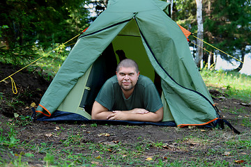 Image showing big smiling man in camping tent
