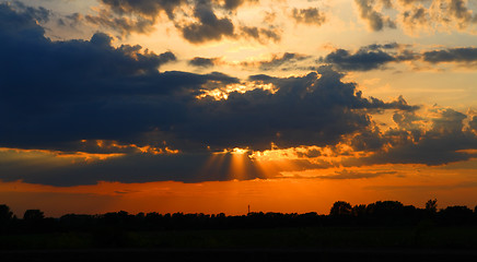 Image showing sun behind dark clouds in sky