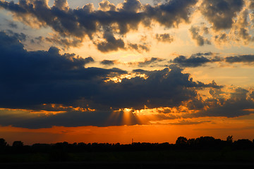 Image showing sun behind dark clouds in sky