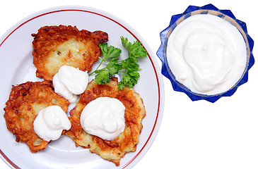 Image showing potato pancakes with sour cream isolated on white