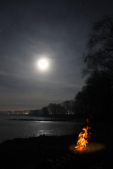 Image showing bonfire flame and moon over lake