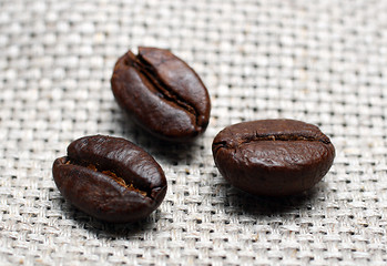 Image showing three coffee beans on canvas background