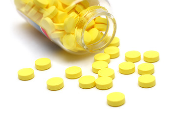Image showing yellow pills around transparent bottle