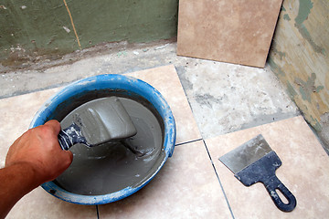 Image showing worker laying ceramicson floor