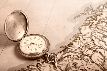 Image showing Old silver watch on old map