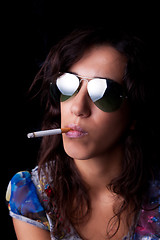 Image showing Young, sexy brunette with cigarette and sunglasses