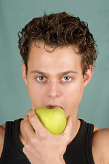 Image showing Young man biting an apple