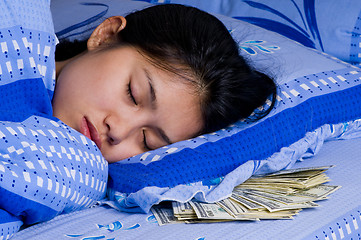 Image showing woman with money under her pillow