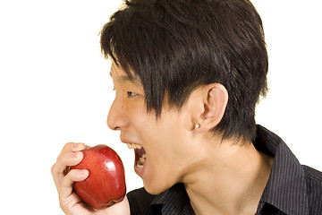 Image showing Young Asian man eating apple