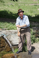 Image showing Man washing hands at spring