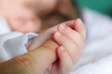 Image showing new born Baby's hand gripping for mothers finger