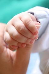 Image showing new born Baby's hand gripping for mothers finger