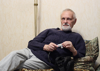 Image showing thoughtful senior with camera