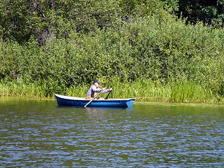 Image showing Fishing men rowing on the boat