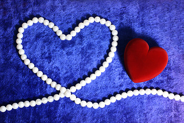 Image showing red heart and pearly neacklace on blue velvet