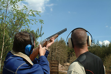 Image showing Man shooting clay pigeons being instructed