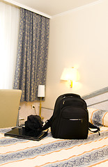 Image showing hotel room with backpack and laptop on bed