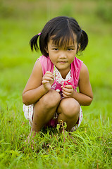 Image showing cute asian girl holding a grasshopper