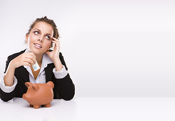 Image showing Savings - Business woman at work holding English  pound currency