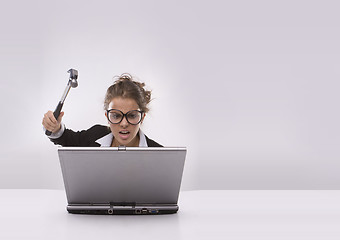 Image showing Angry brunette businesswoman with hammer