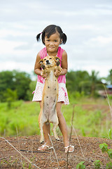 Image showing farmer girl holding a dog
