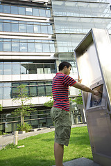 Image showing asia man touch the screen at moder building outside