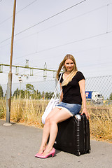 Image showing girl sitting on a suitcase