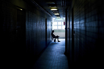 Image showing man sitting in the corridor in a building