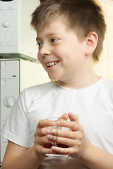 Image showing Smiling kid in white with tea